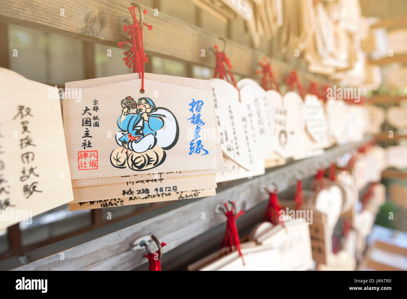Japanese Ema or small wooden votive plaques on which Shinto worshippers write their prayers or wishes then left hanging up at a shrine Stock Photo