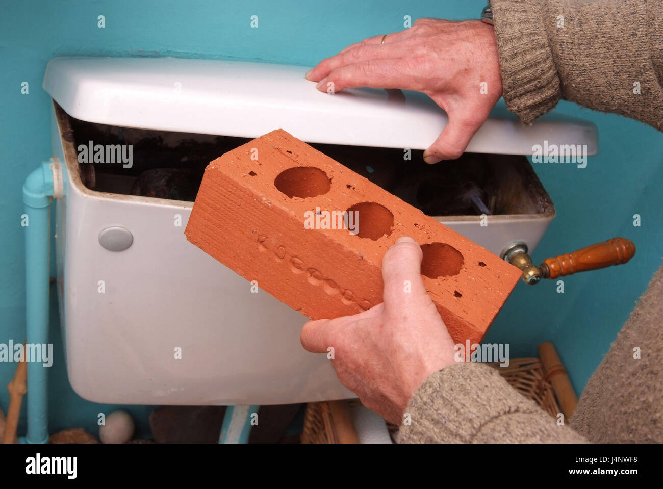 Using a building brick in a WC cistern to save water Stock Photo