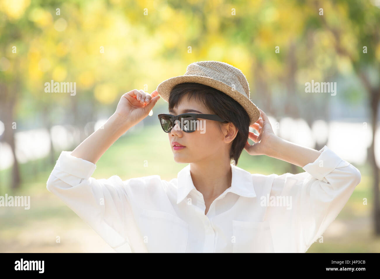 portrait of young beautiful asian woman wearing sun glasses and straw ...