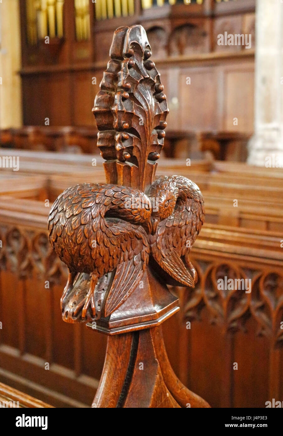 A carved poppy head on a pew end in the parish church of St Michael at Aylsham, Norfolk, England, United Kingdom. Stock Photo