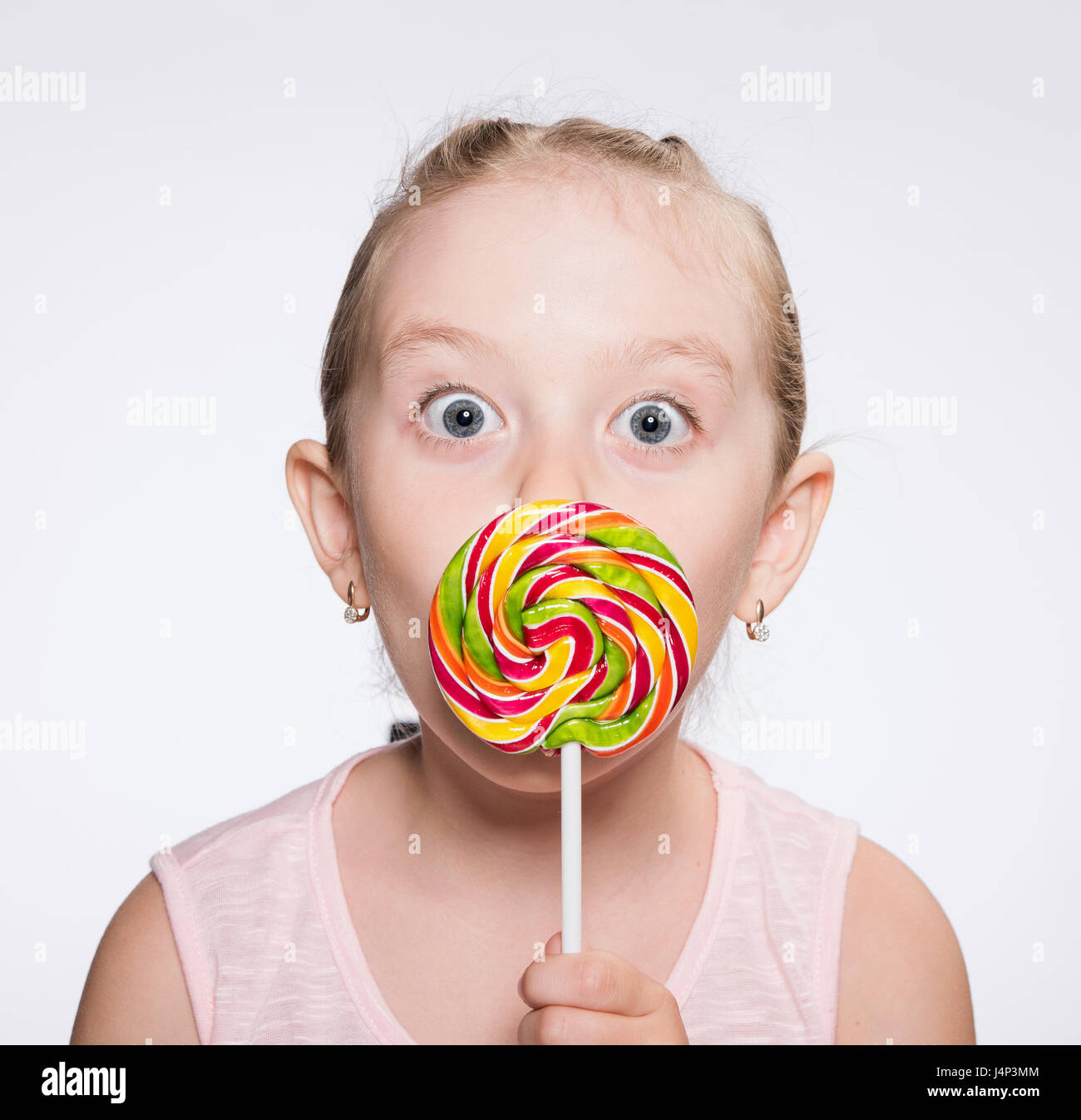 girl licks a bright icicle on a stick Stock Photo