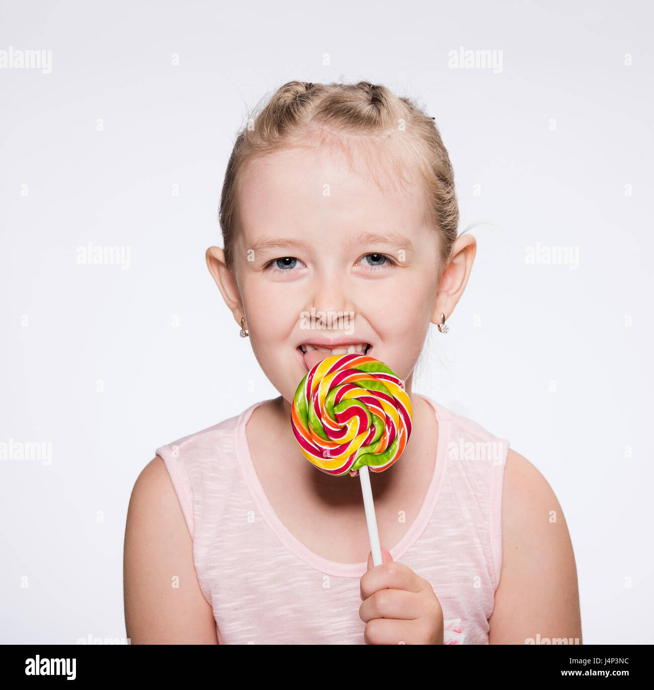 young girl licks a bright icicle Stock Photo