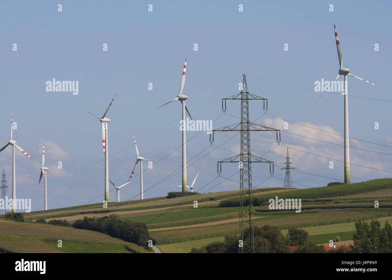 Wind turbines hills meadows turbines high voltage poles