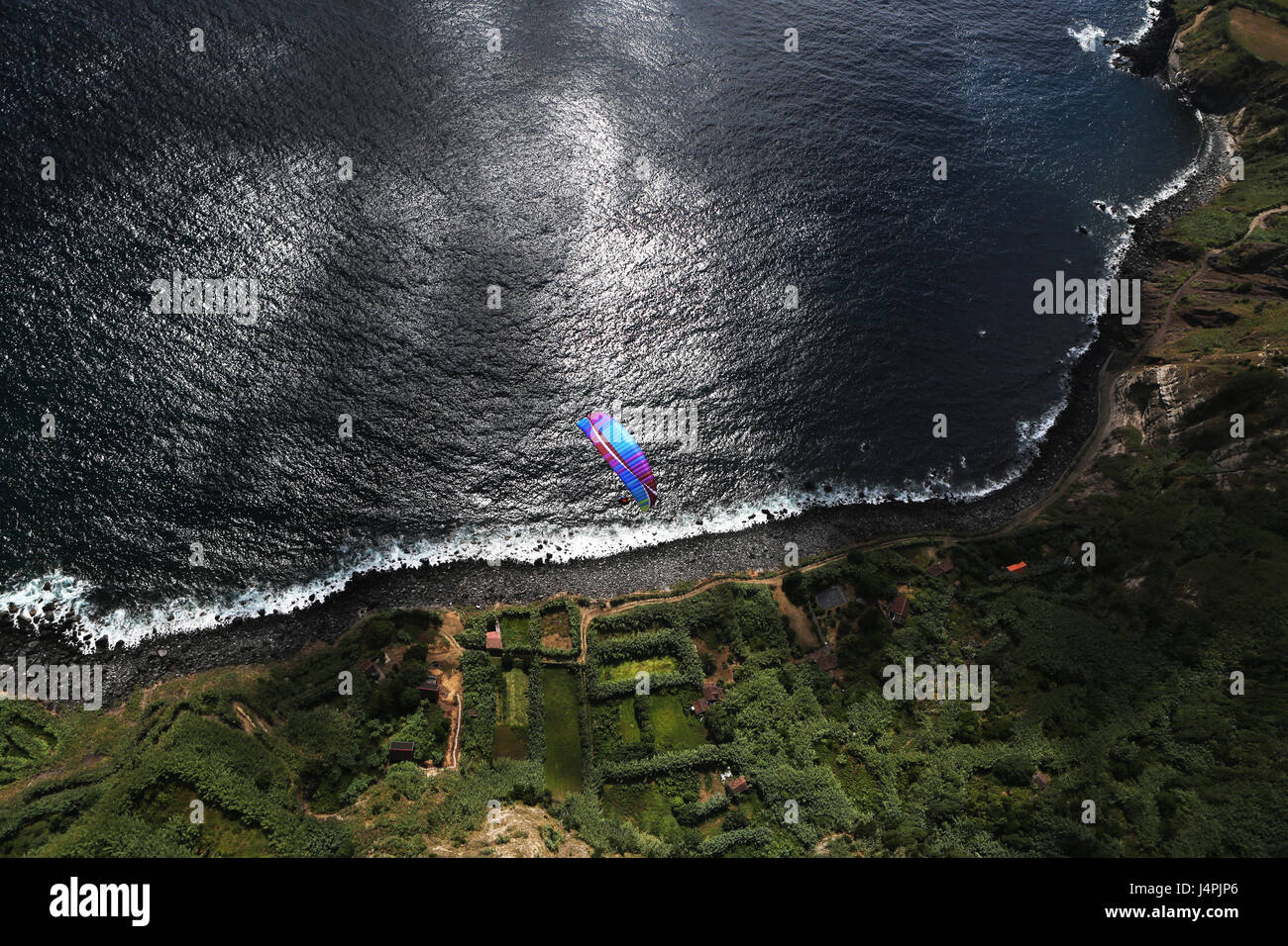 A female paragliding pilot flying during the 22nd Azores Paragliding