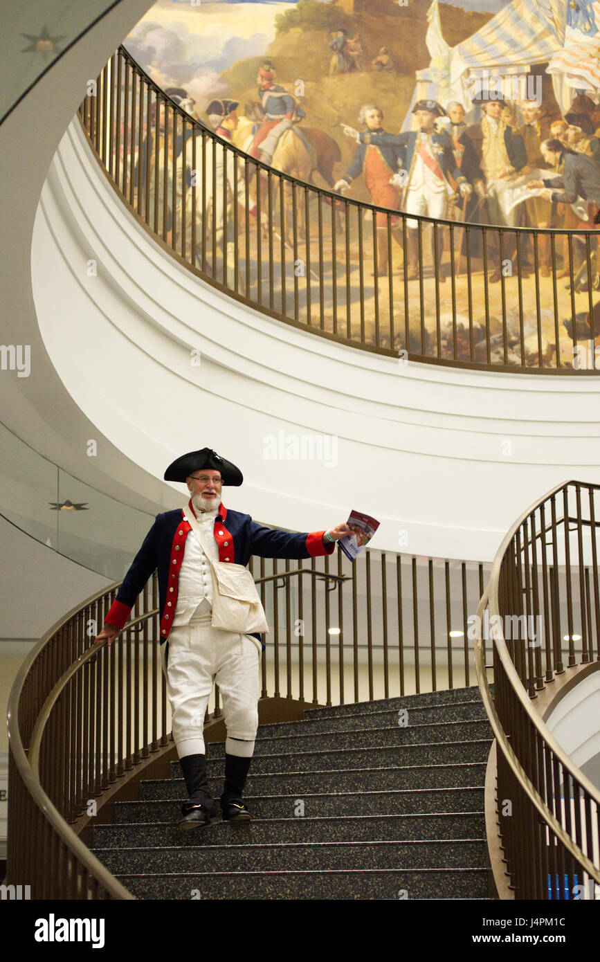 Revolutionary War re-enactor ascends the center staircase of the Museum of the American Revolution, in Philadelphia, PA. Stock Photo