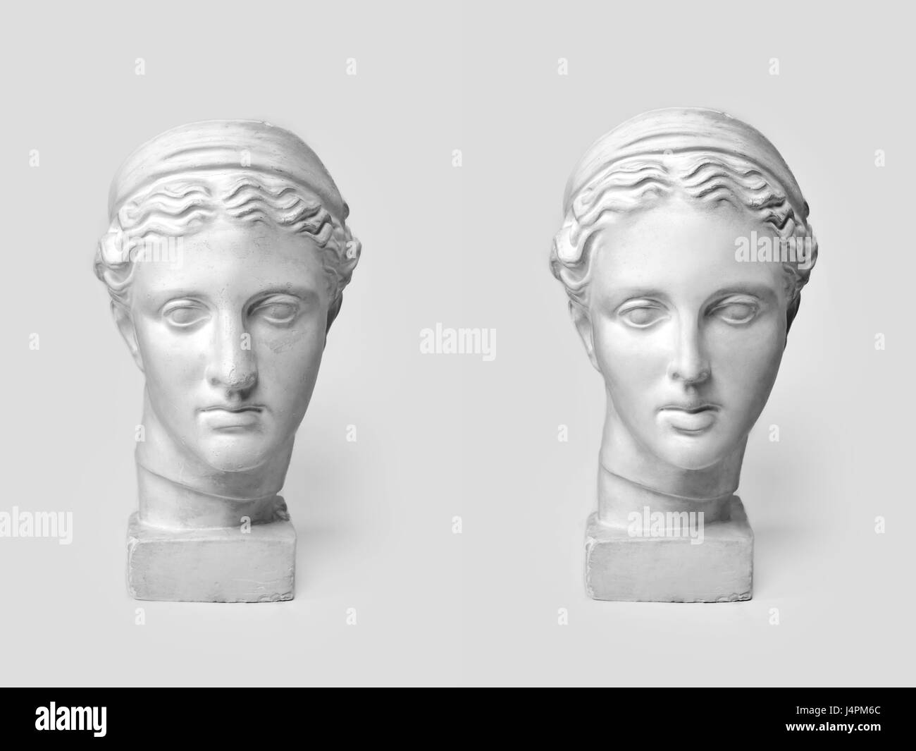 Two marble heads of young women, ancient Greek goddess bust before plastic surgery and after operation on light background. Old and new beauty standarts concept. Stock Photo