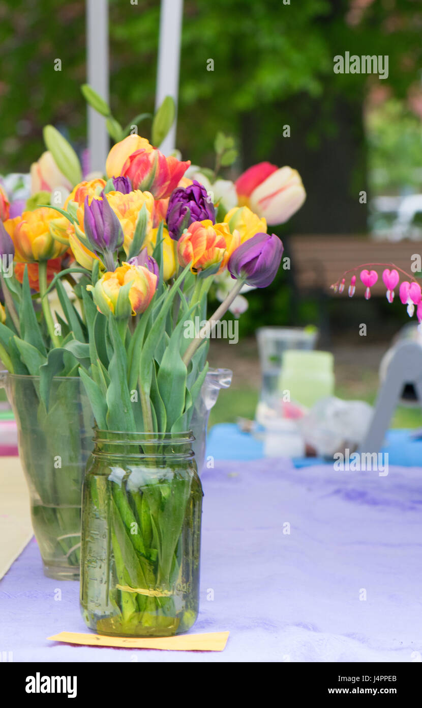 A row of flower bouquets in mason jars at a farmer's market Stock Photo