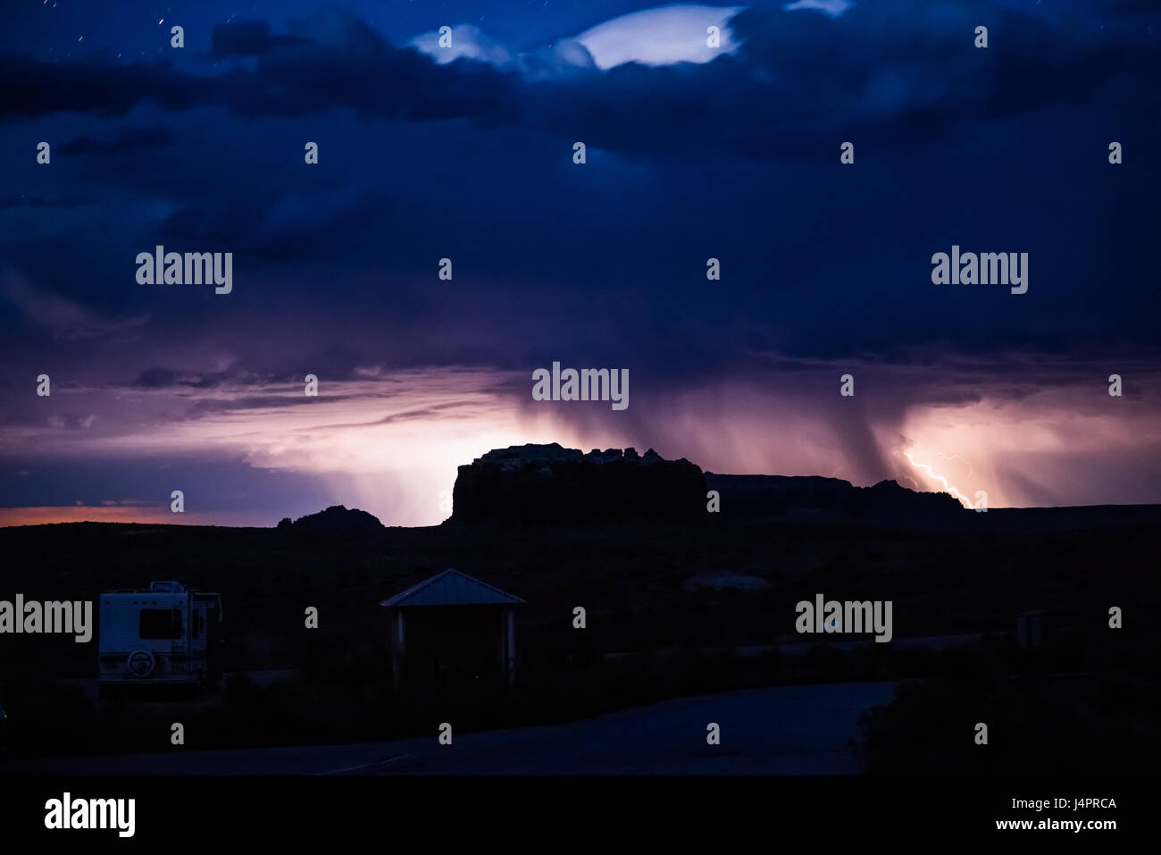 Night sky during the thunderstorm in the distance with canyons and campground Stock Photo