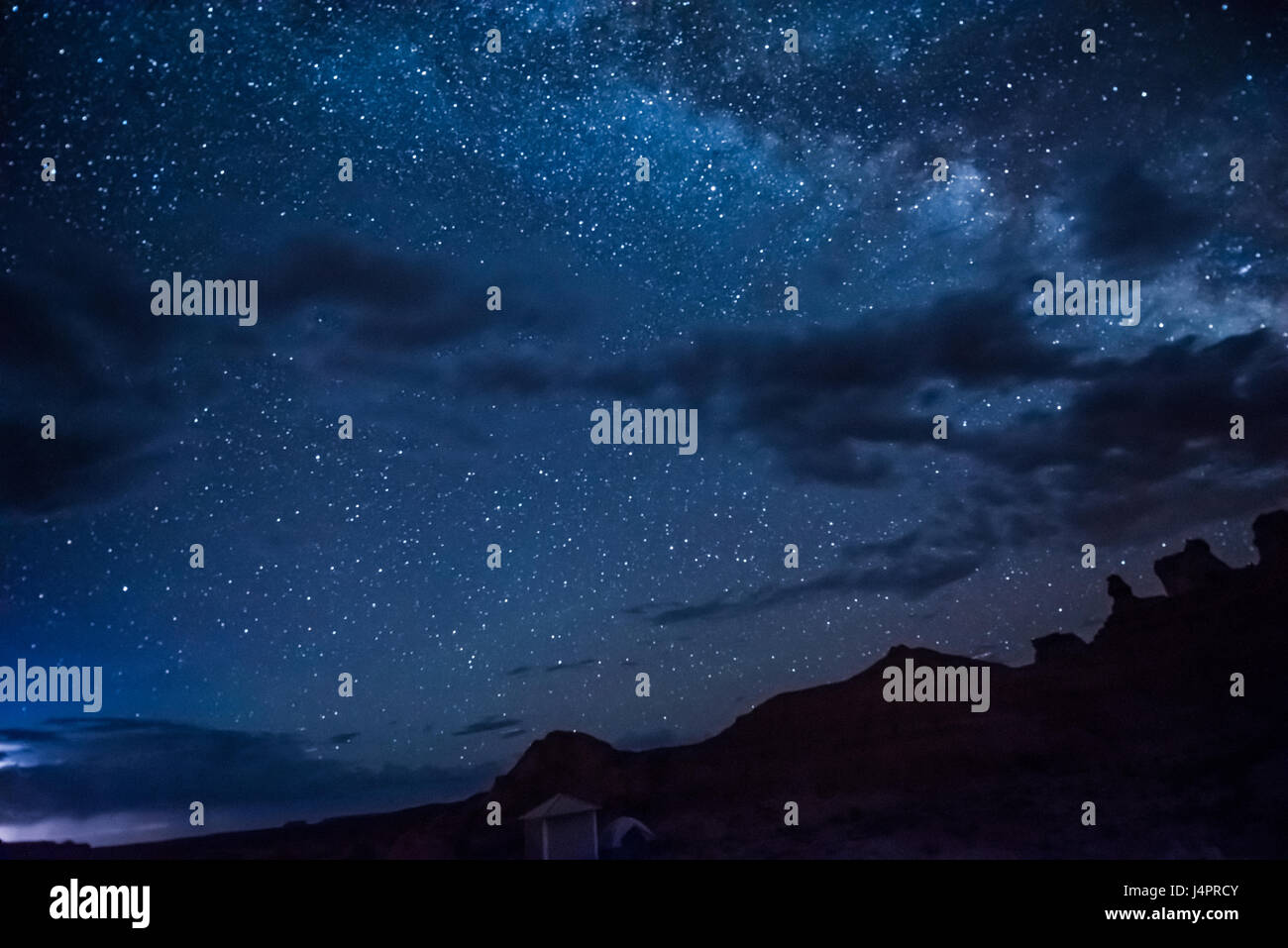 Night sky with milky way, clouds, canyons and campground Stock Photo