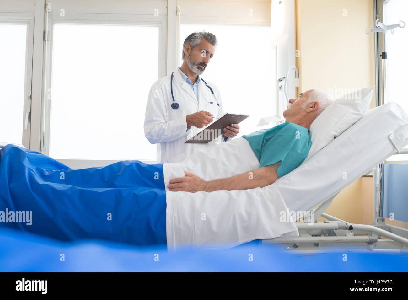 doctor visiting his senior patient at hospital Stock Photo