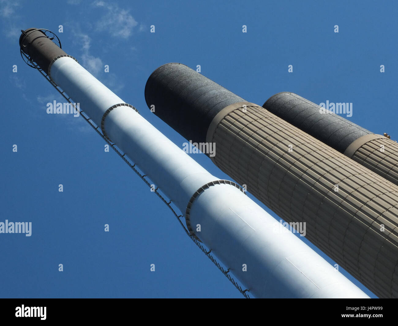 tall industrial chimneys in concrete and steel with blue sky Stock
