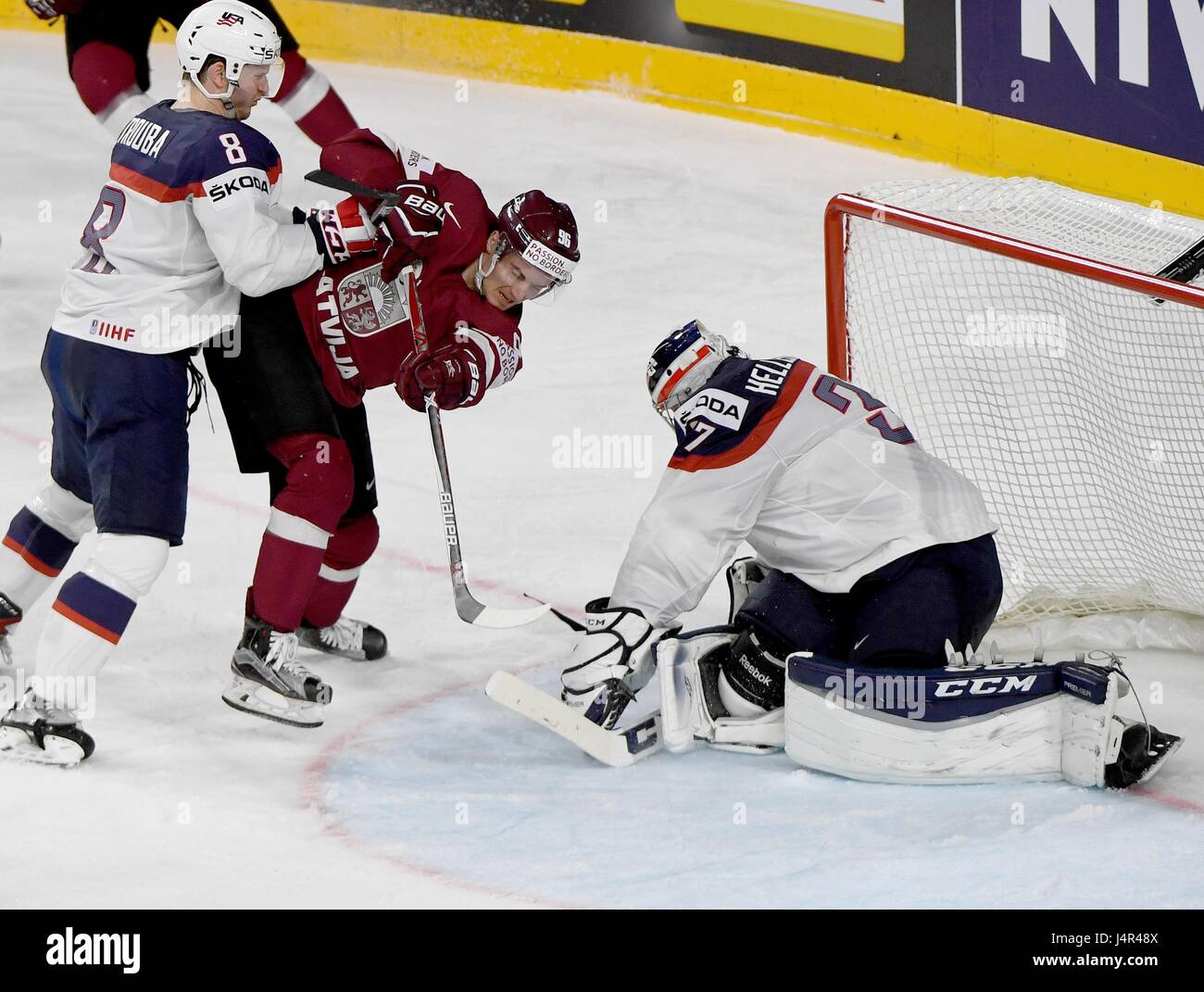 Cologne, Germany. 12th May, 2017. Latvia's Maris Bicevskis (M) tries to  score against US goalkeeper Connor Hellebuyck (R) during the Ice Hockey  World Championship group match between Latvia and USA at the