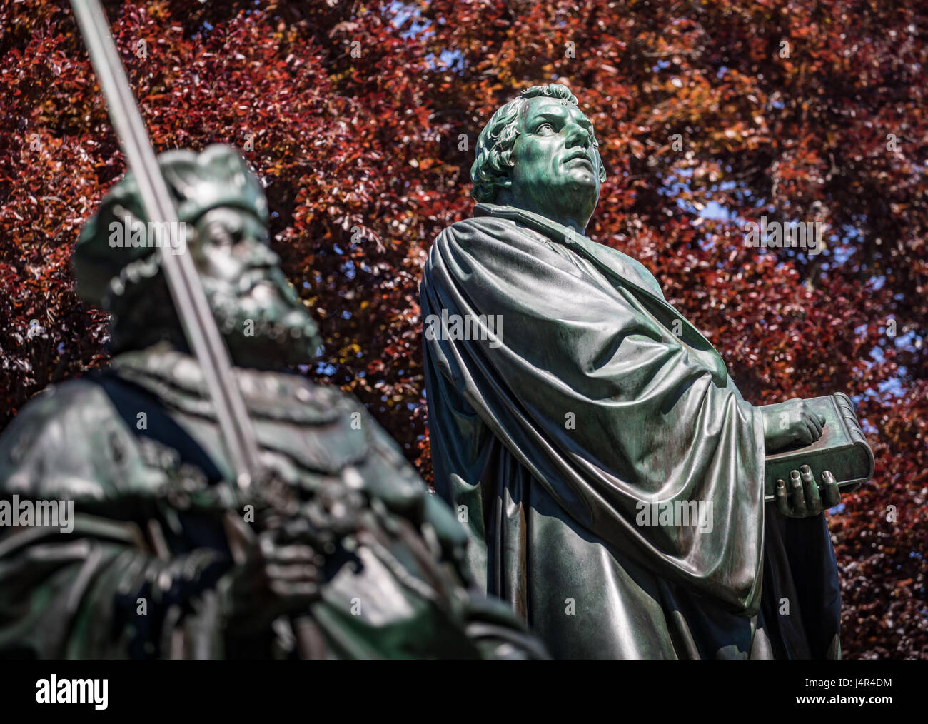 Worms, Germany. 9th May, 2017. A giant statue of Martin Luther, the center of the Luther memorial from 1868, can be seen behind a statue of Frederick I of Prussia (l) in Worms, Germany, 9 May 2017. One of the highlights of the celebration of the 500th anniversary of the Reformation is the opening of the Luther Way ('Lutherweg') 1521 between Eisenach and Worms on Sunday, 14 May 2017. The roughly 400 kilometer long pilgrimage path is said to attract hikers and tourists. Photo: Frank Rumpenhorst/dpa/Alamy Live News Stock Photo
