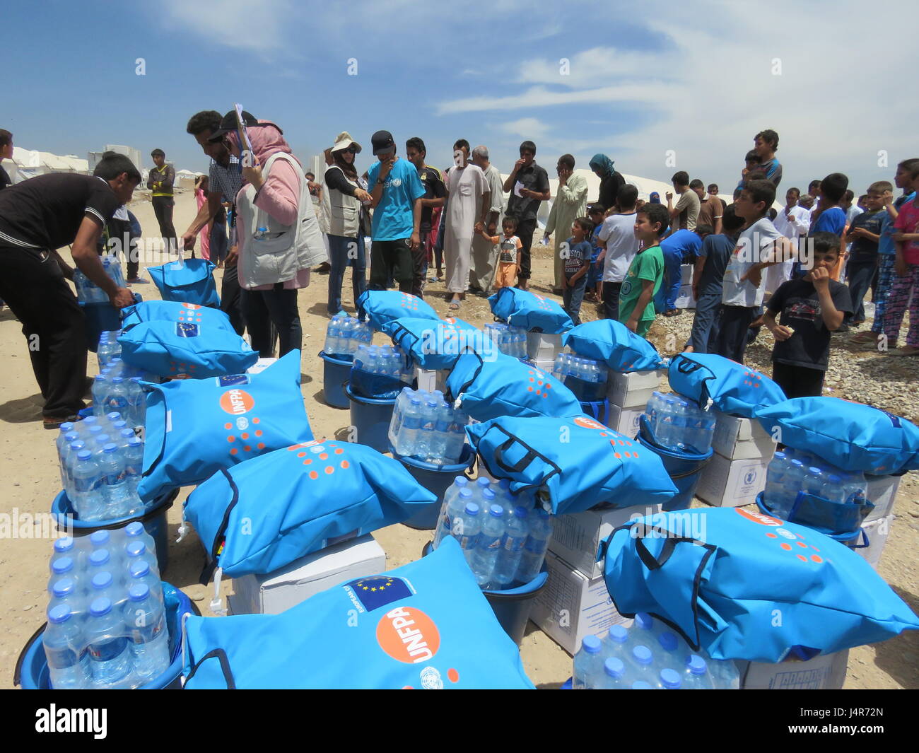 Mosul, Iraq. 13th May, 2017. People get relief supplies in the Hassansham U2 Camp, about 30 kms east to Mosul, Iraq, on May 13, 2017. The camp has a capacity to accommodate more than 9,000 people when fully occupied. According to Iraqi authorities, more than 630,000 people have been displaced from Mosul and surrounding areas since October 2016, when the military operation began. This includes more than 434,000 displaced from western Mosul since mid-February of this year. Credit: Khalil Dawood/Xinhua/Alamy Live News Stock Photo