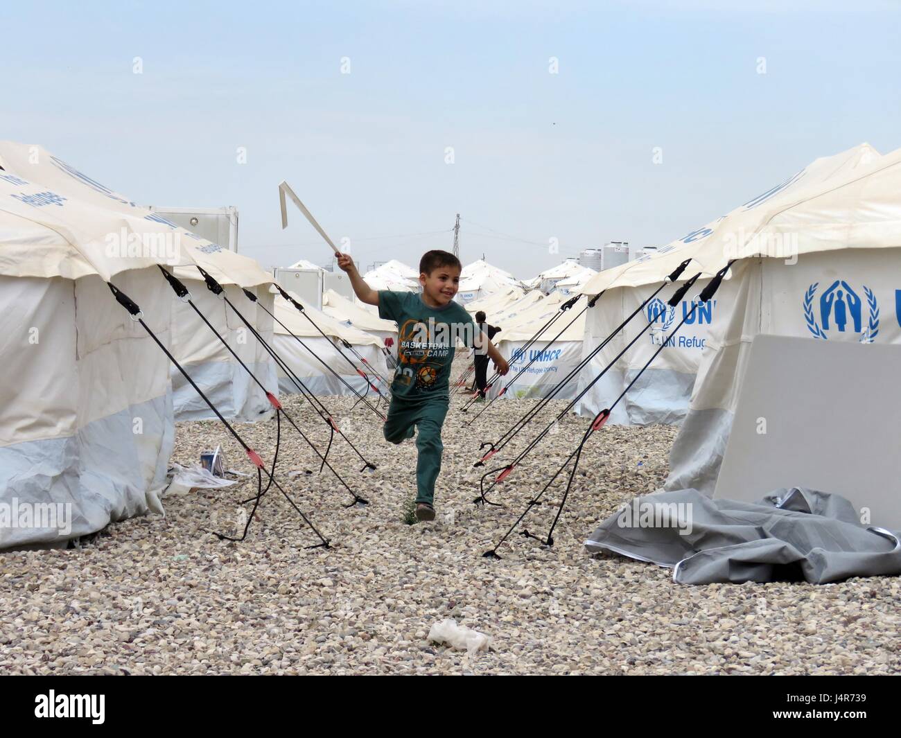 Mosul, Iraq. 13th May, 2017. A boy runs in the Hassansham U2 Camp, about 30 kms east to Mosul, Iraq, on May 13, 2017. The camp has a capacity to accommodate more than 9,000 people when fully occupied. According to Iraqi authorities, more than 630,000 people have been displaced from Mosul and surrounding areas since October 2016, when the military operation began. This includes more than 434,000 displaced from western Mosul since mid-February of this year. Credit: Khalil Dawood/Xinhua/Alamy Live News Stock Photo