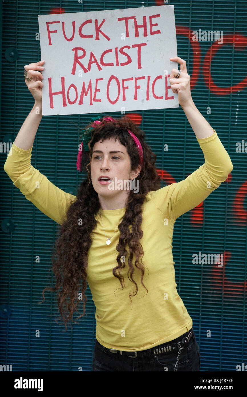 Milton Ernest, UK. 13th May, 2017. A campaigner against immigration detention holds up a sign as she kicks the perimeter fence of Yarl's Wood Immigration Removal Centre during a protest organised by Movement For Justice By Any Means Necessary. Campaigners, including former detainees, called for all immigration detention centres to be closed. Credit: Mark Kerrison/Alamy Live News Stock Photo