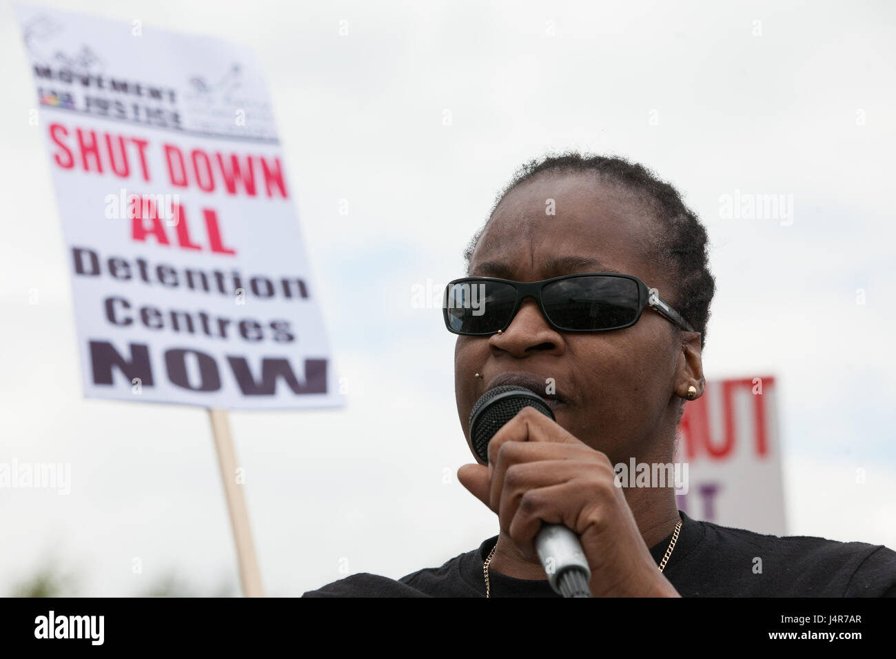 Milton Ernest, UK. 13th May, 2017. Denise McNeil, who went on hunger strike whilst at Yarl's Wood Immigration Removal Centre, addresses over a thousand campaigners against immigration detention attending a protest organised by Movement For Justice By Any Means Necessary outside the detention centre. Campaigners, including former detainees, called for all immigration detention centres to be closed. Credit: Mark Kerrison/Alamy Live News Stock Photo