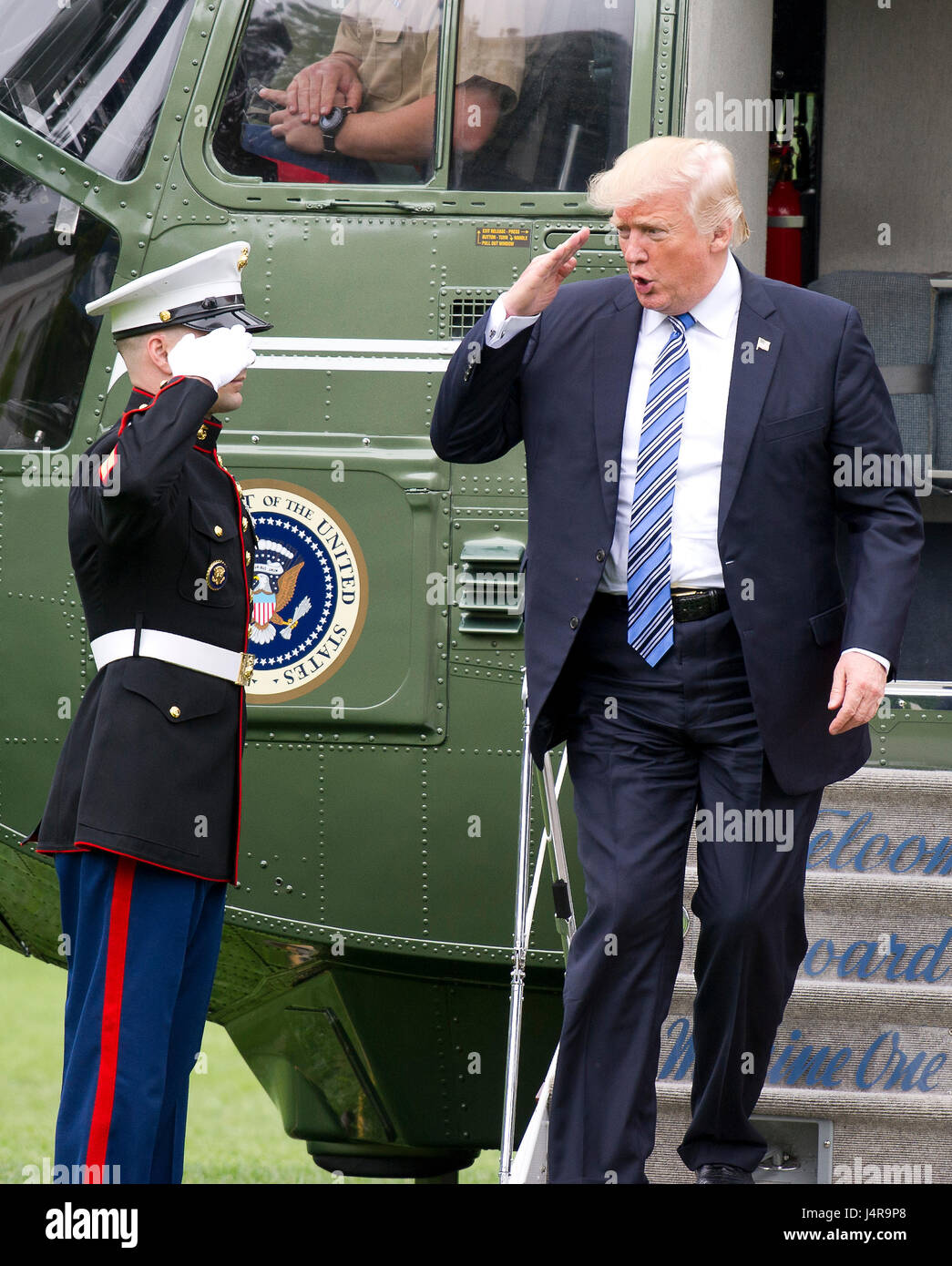 United States President Donald J. Trump salutes the Marine Guard as he