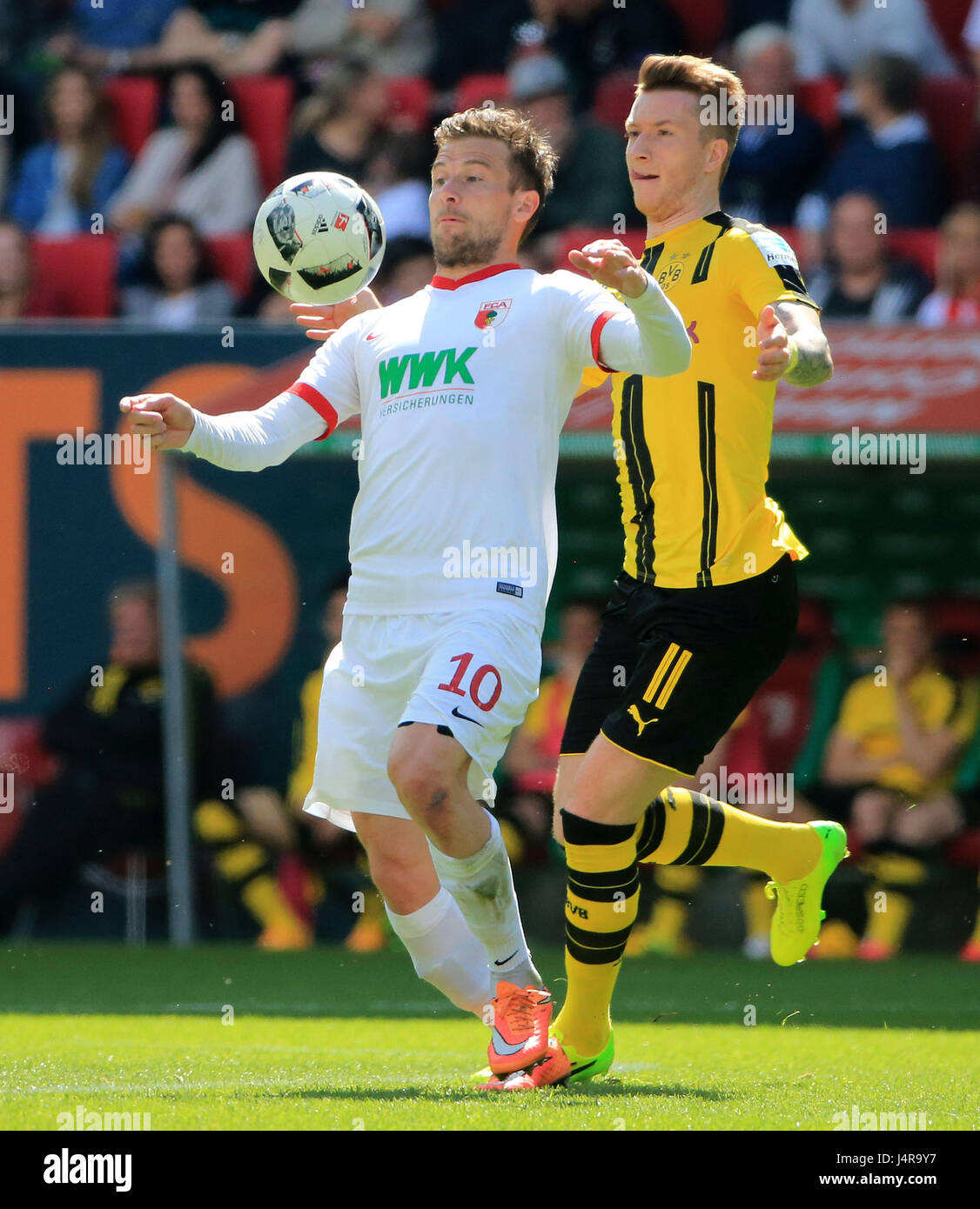 Augsburg, Germany. 13th May, 2017. FC Augsburg's Daniel Baier (L) vies with Borussia Dortmund's Marco Reus during a German Bundesliga match between FC Augsburg and Borussia Dortmund in Augsburg, Germany, May 13, 2017. The match ended 1-1. Credit: Philippe Ruiz/Xinhua/Alamy Live News Stock Photo
