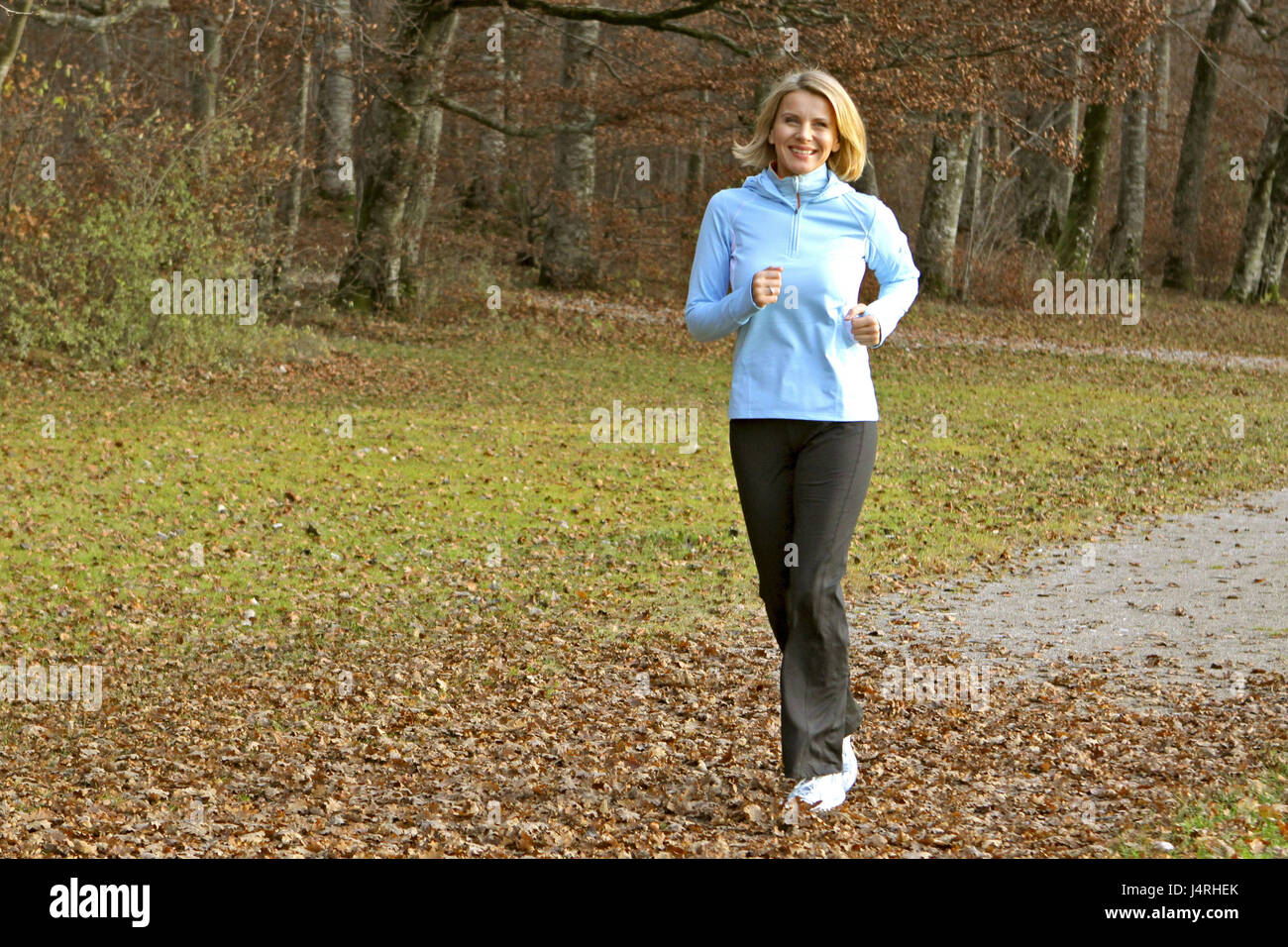 Blond woman, with the jogging in an autumn wood, model released, Stock Photo
