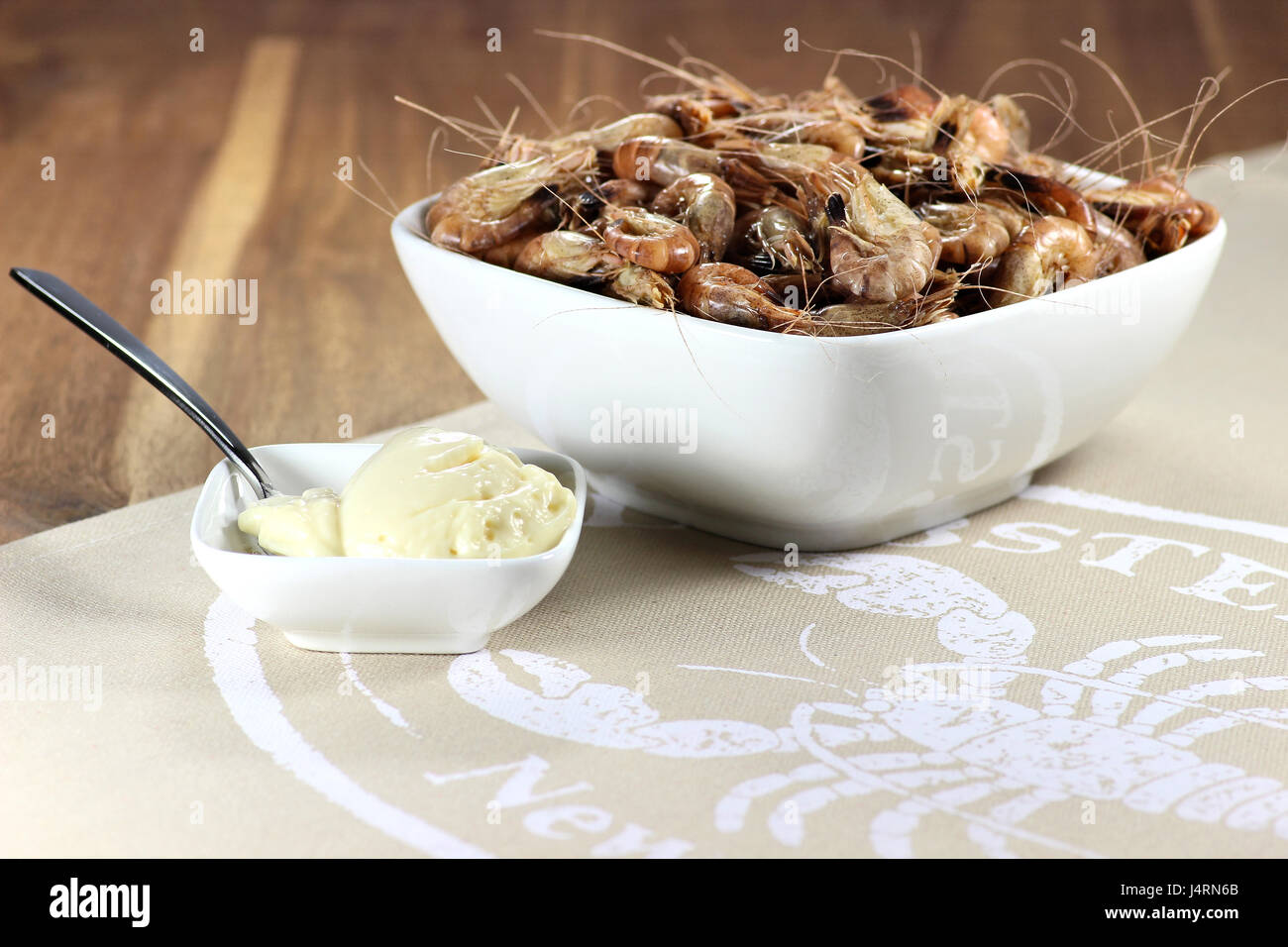 unpeeled brown shrimps in a ceramic bowl Stock Photo
