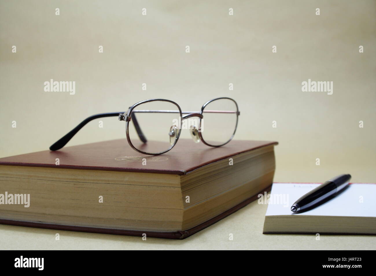 Reading Glasses on Book with Note Pad and Pen Stock Photo Alamy