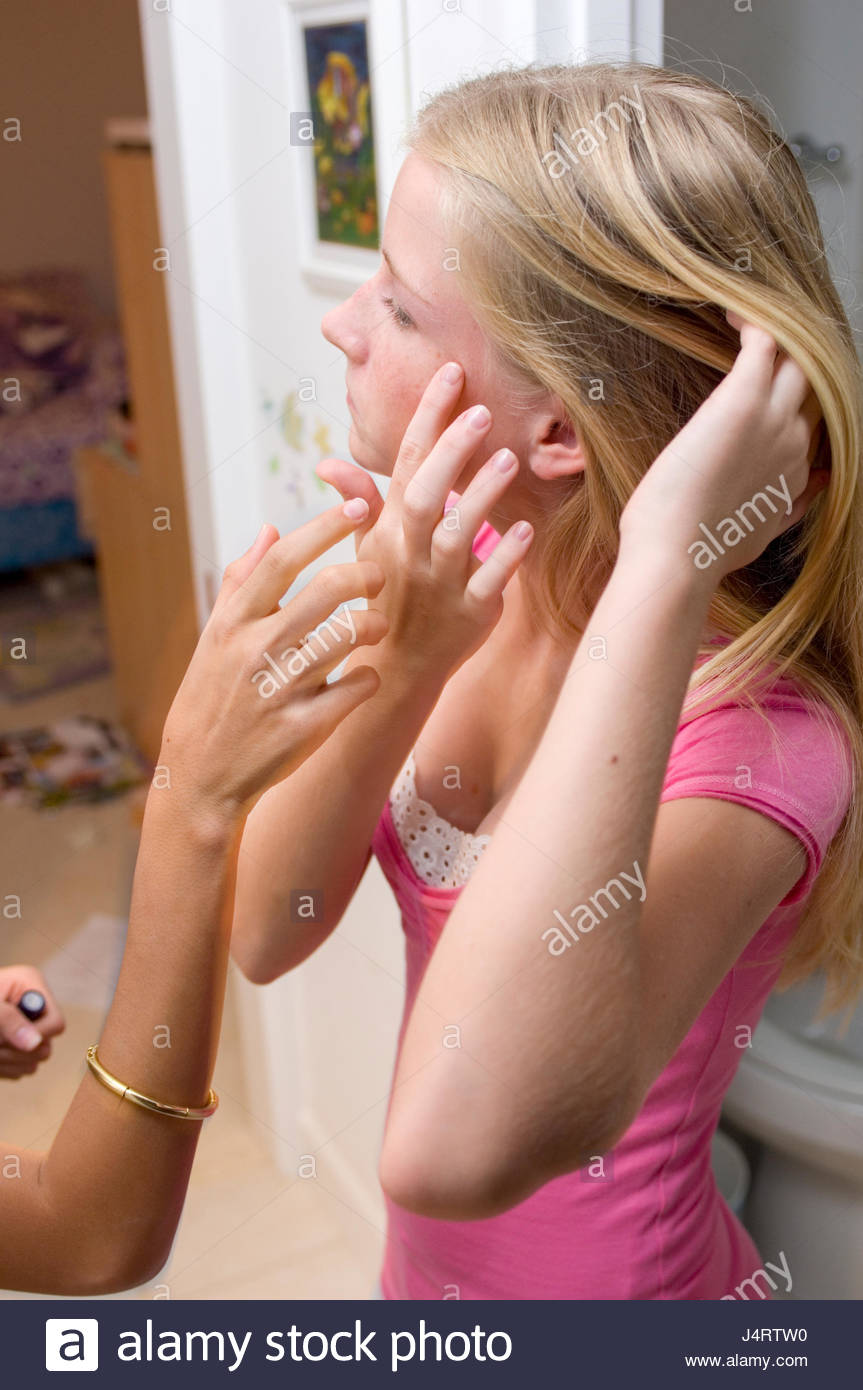 Teenage Girl With Blond Hair And Freckles Looking Into A Mirror As