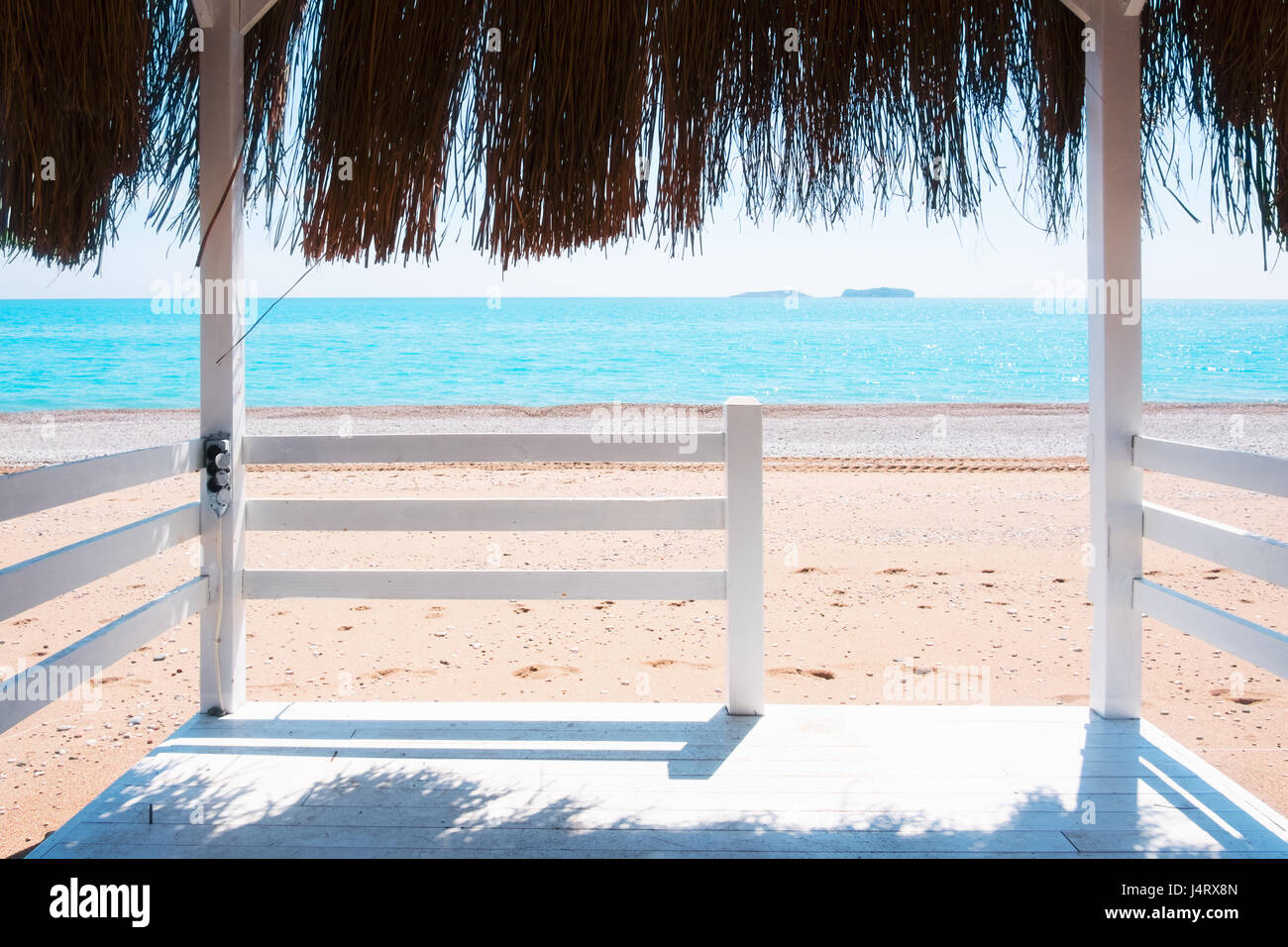 Summer arbor on beach. Breathtaking view on mediterranean sea. White wooden summerhouse on sunny day Stock Photo