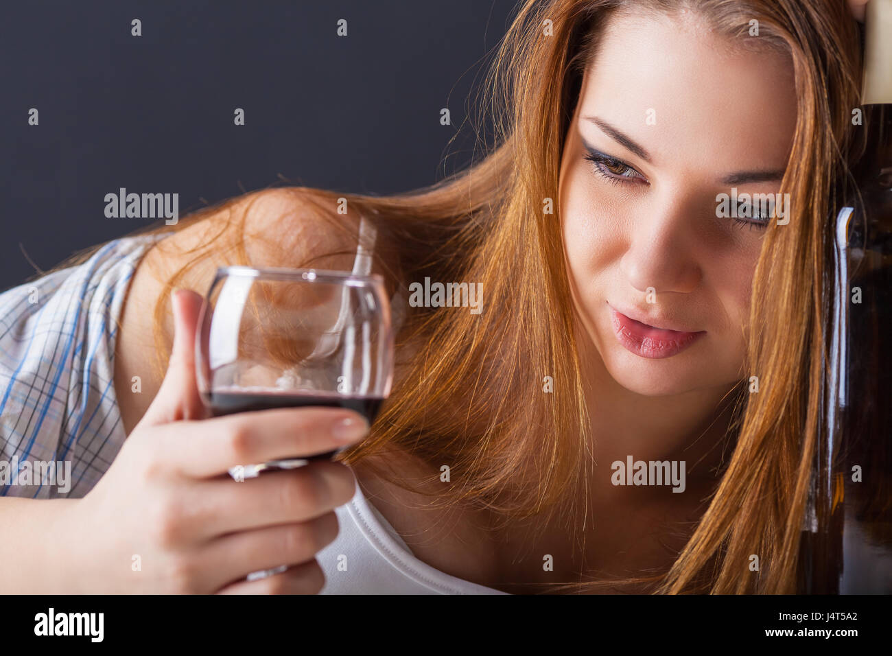 Young beautiful woman with a glass of wine on a dark background Stock Photo