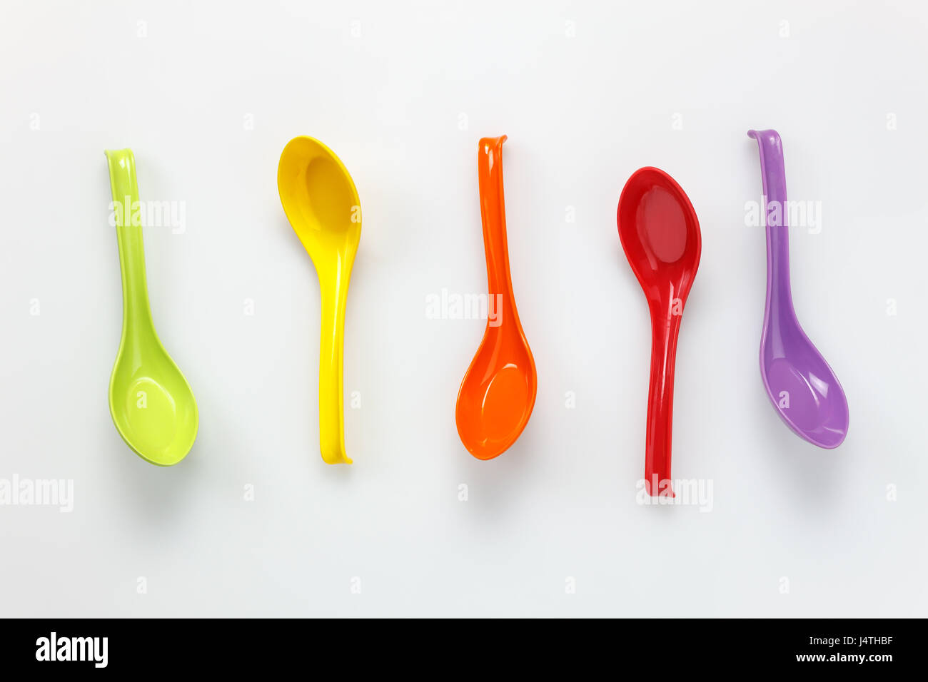Top view colorful plastic spoon on white table background with copy ...