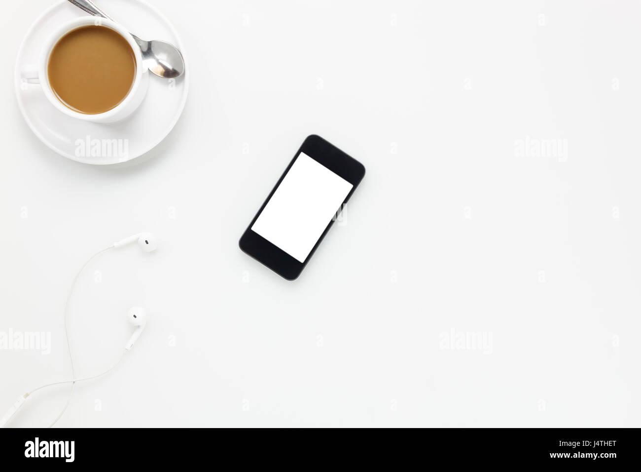 Top view  accessories office desk.smartphones earphones and cup of coffee on white background. Stock Photo