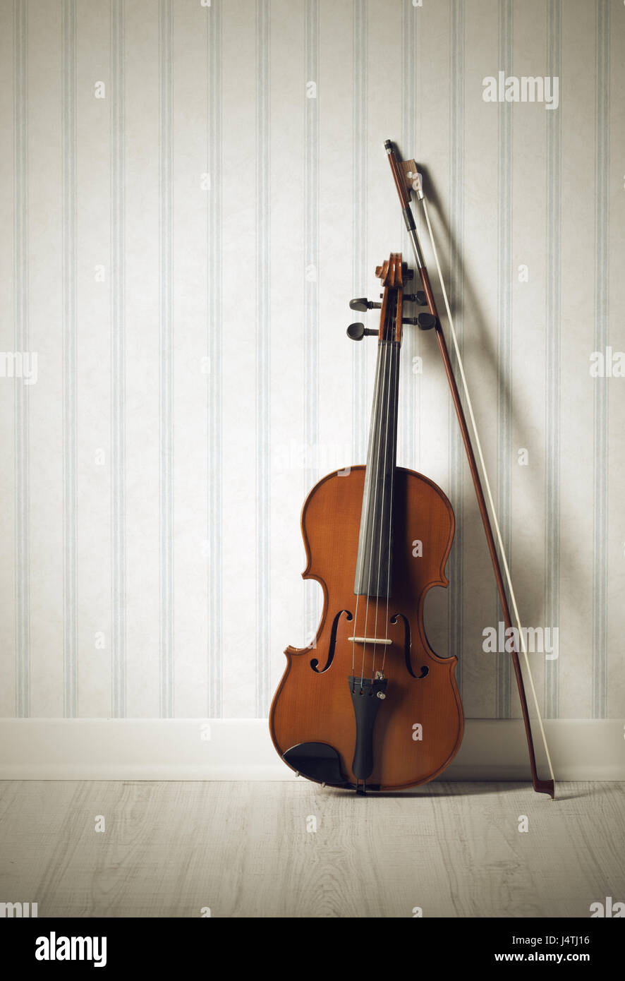 Violin and bow on a vintage wallpaper Stock Photo - Alamy