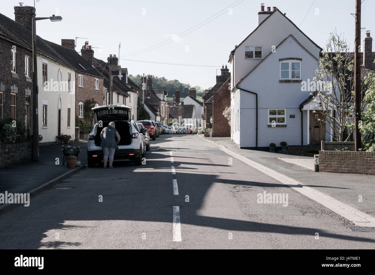 A sunny day on Barrow Street in Much Wenlock, Shropshire, UK.  A lazy Sunday afternoon and a scenic British road.. Stock Photo