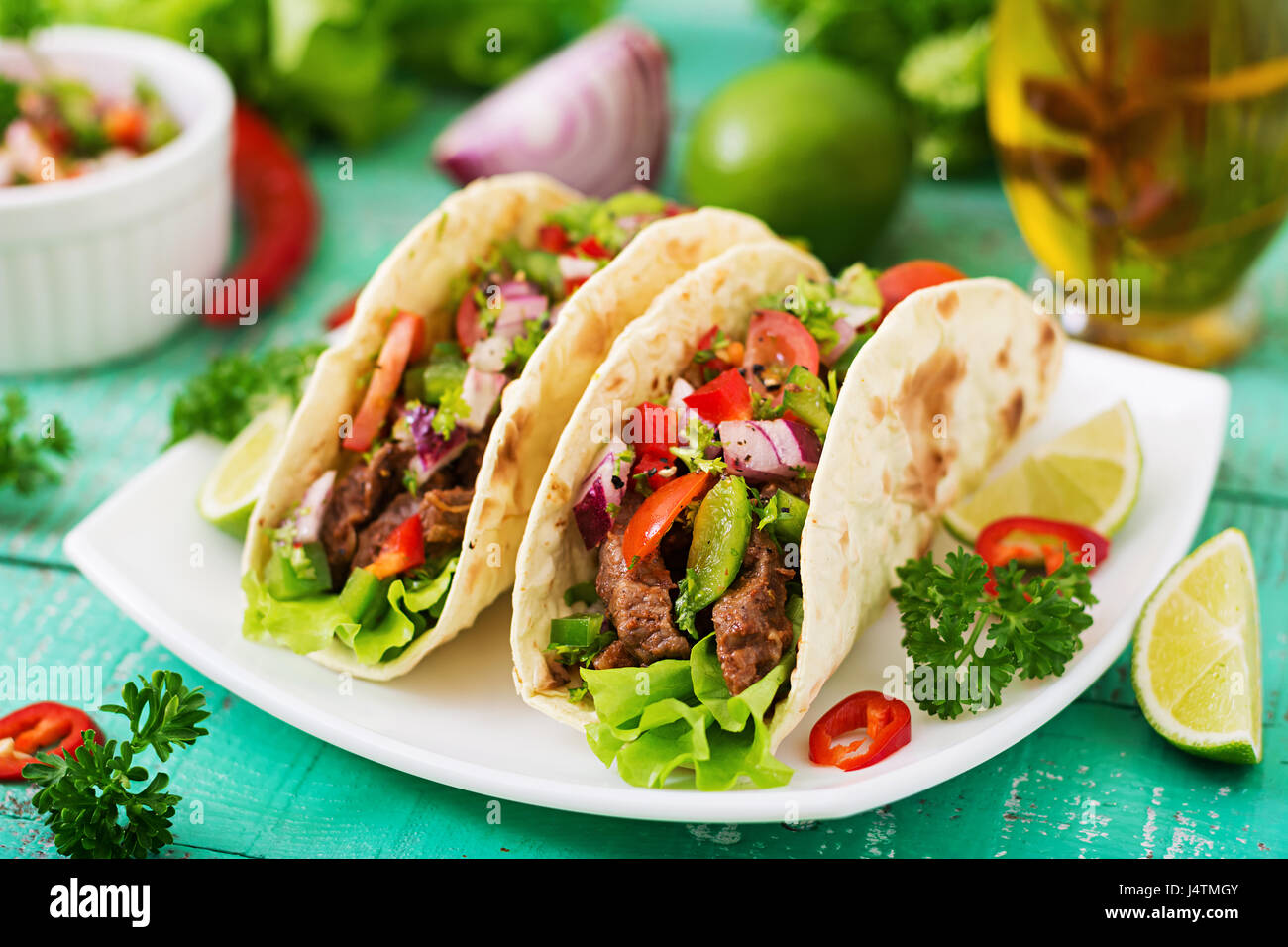 Mexican tacos with beef in tomato sauce and salsa Stock Photo