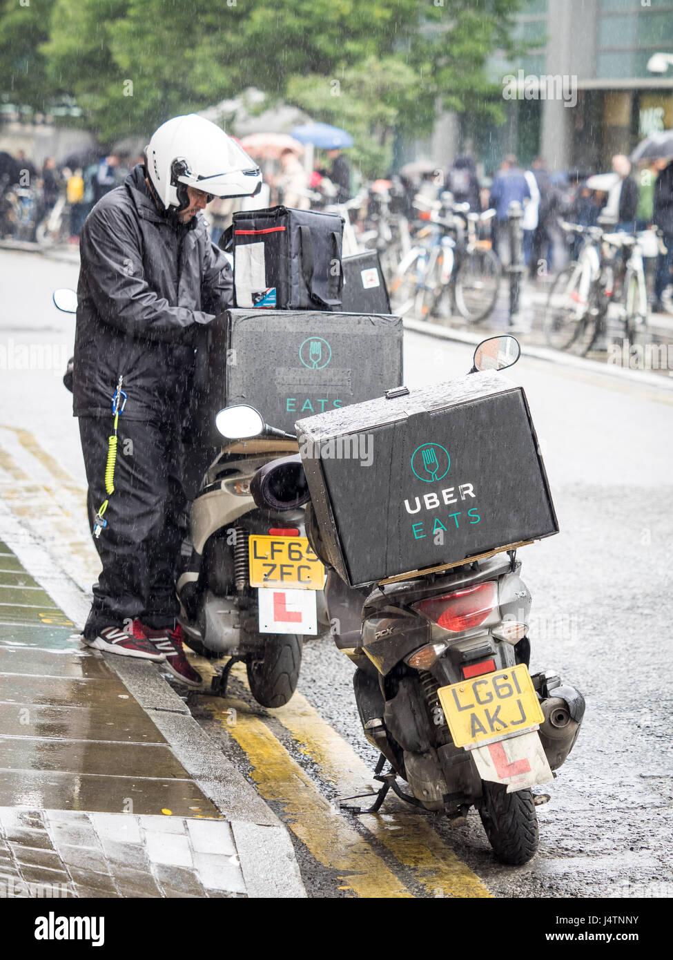 An Uber Eats food delivery courier prepares to deliver food to a customer  from a restaurant in central London. Uber Eats competes with rival  Deliveroo Stock Photo - Alamy