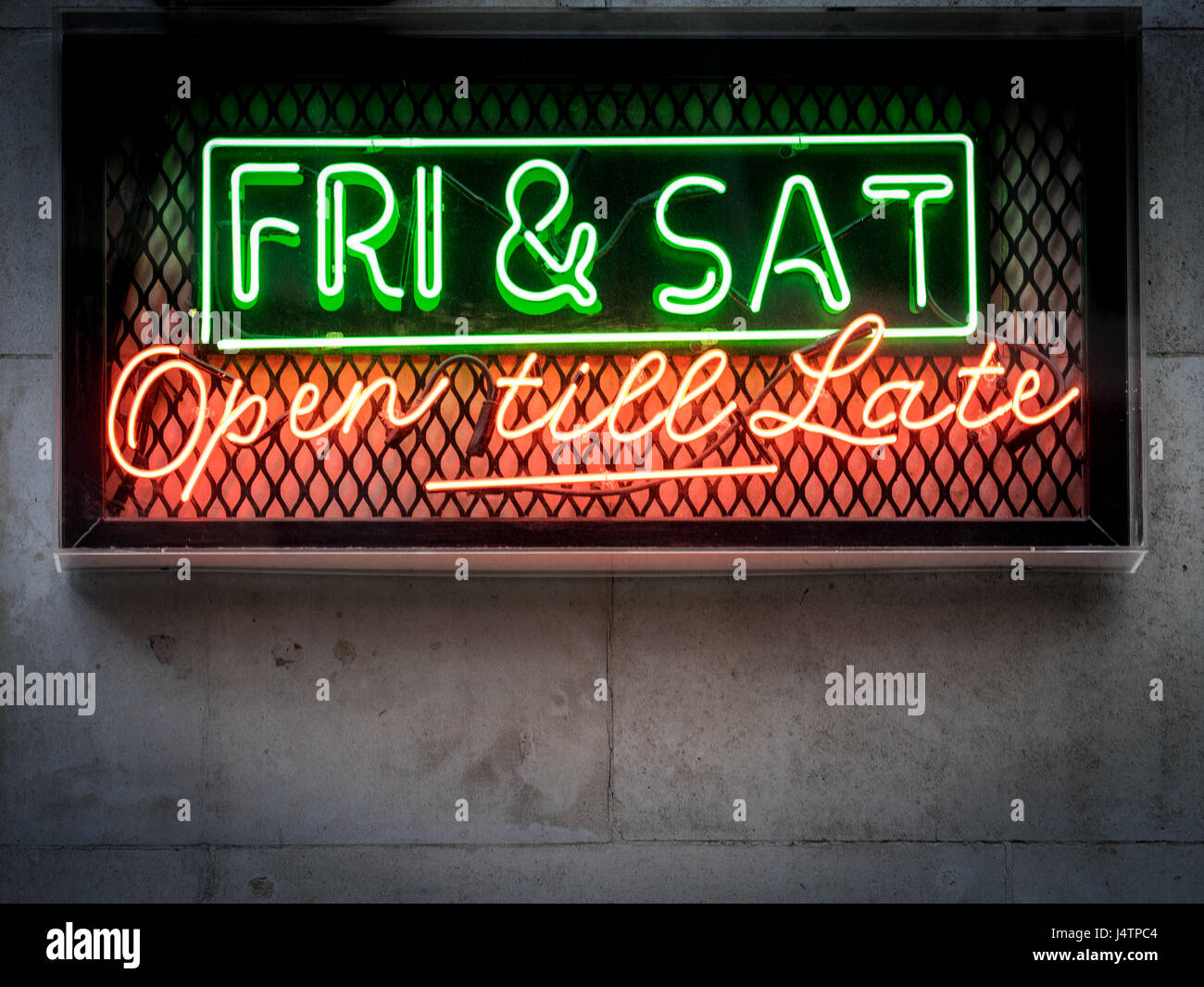 Late night opening neon sign outside a bar in London's popular Soho district Stock Photo