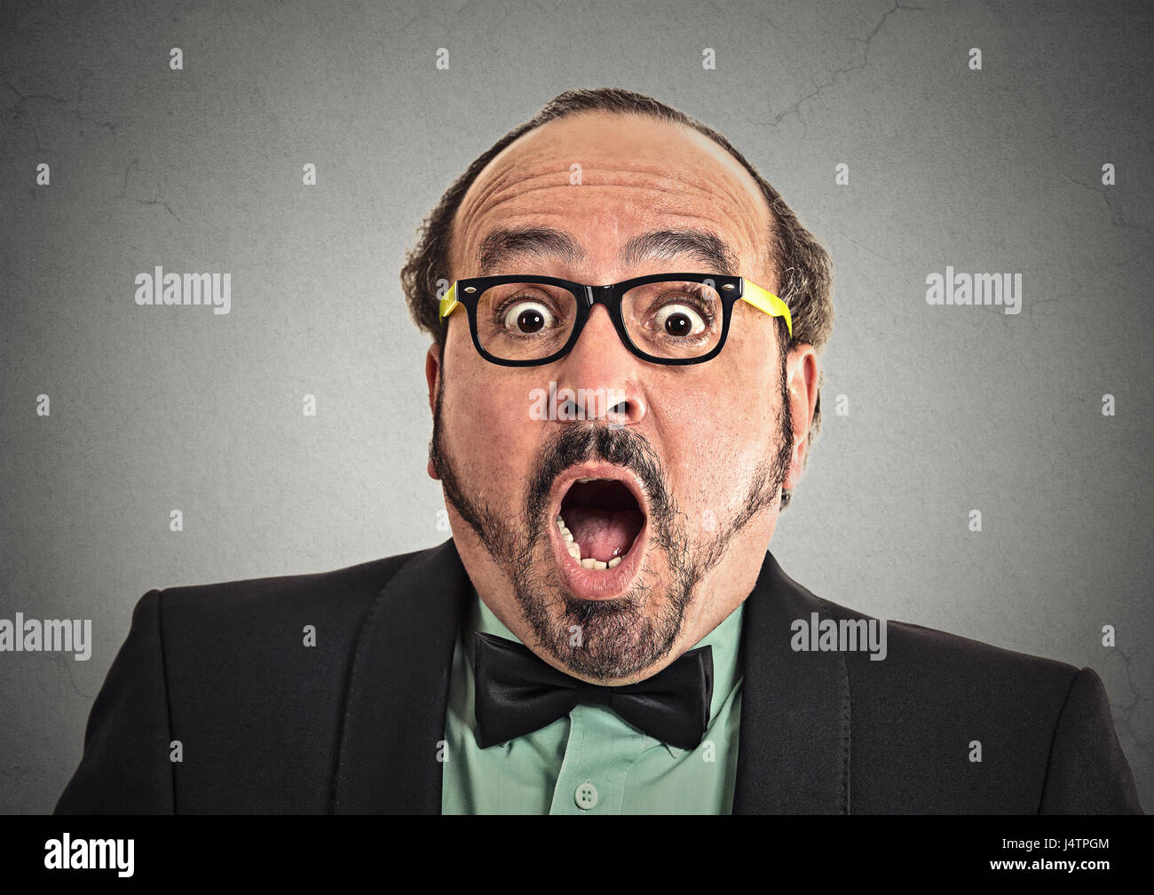 Surprise astonished man. Closeup portrait man looking surprised in full disbelief wide open mouth isolated grey wall background. Positive human emotio Stock Photo