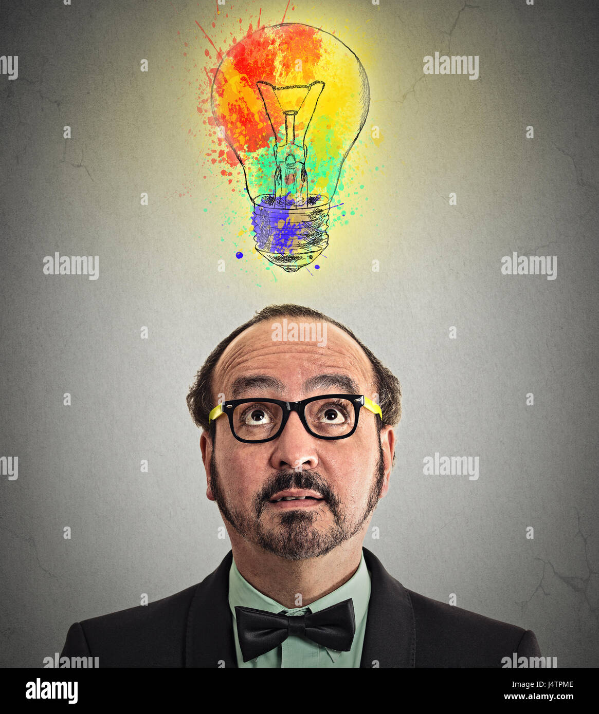 headshot man having brilliant idea colorful lightbulb above head isolated grey wall background. Human face expression emotion perception. Creativity i Stock Photo