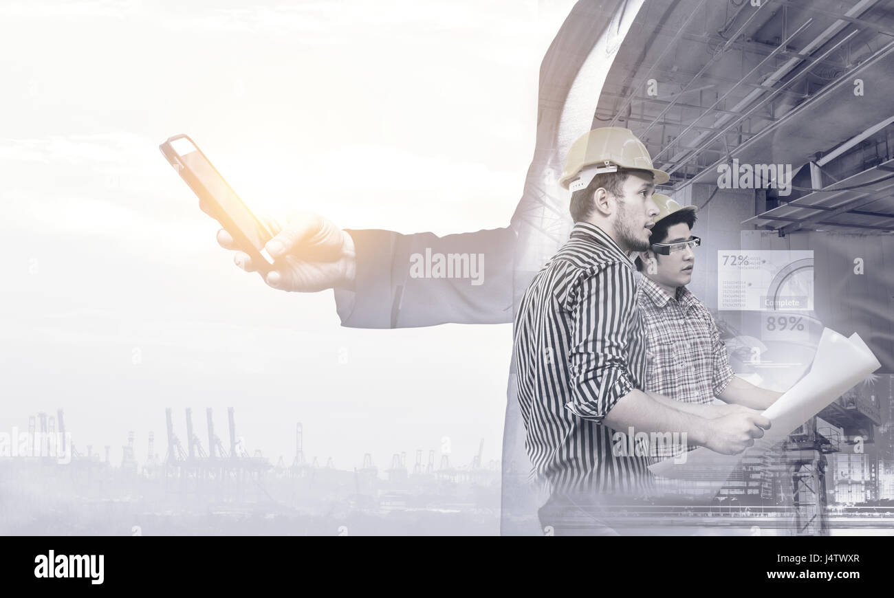 Smart construction , augmented reality in industry 4.0 concept. Double exposure of Business hand suit using mobile phone and two engineers using ar gl Stock Photo