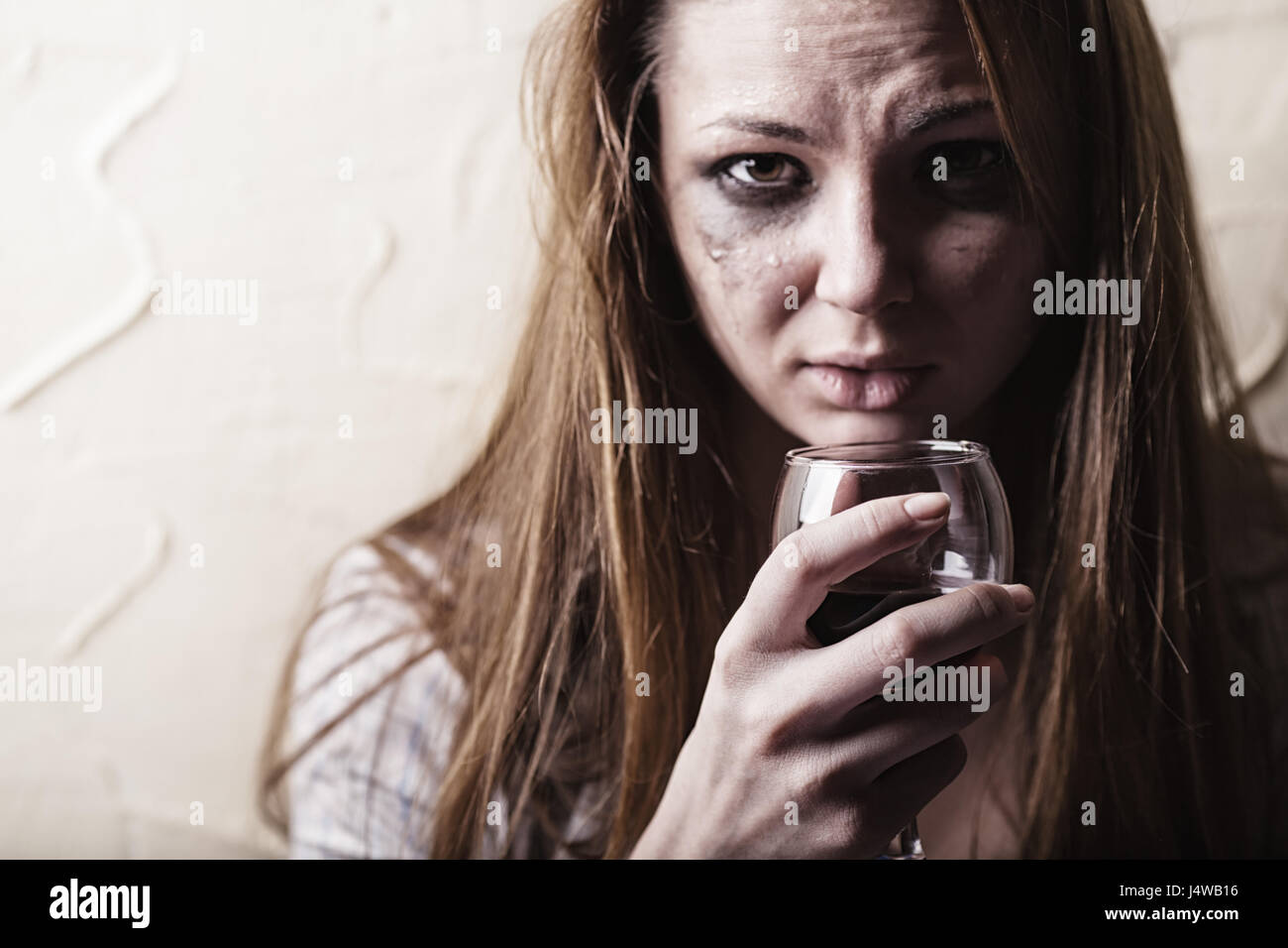Young crying woman with a glass of wine Stock Photo