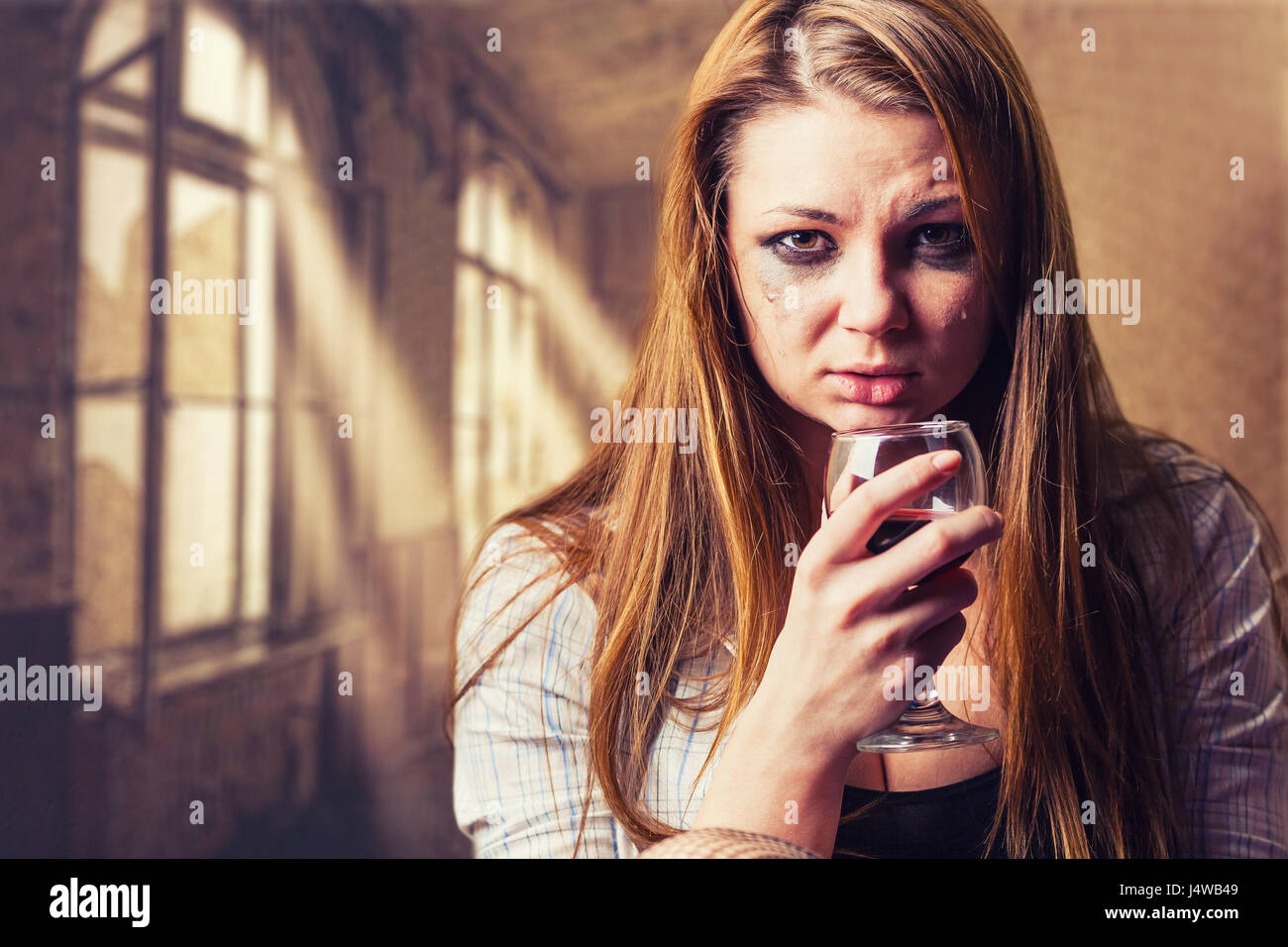Young beautiful woman in depression, drinking alcohol Stock Photo