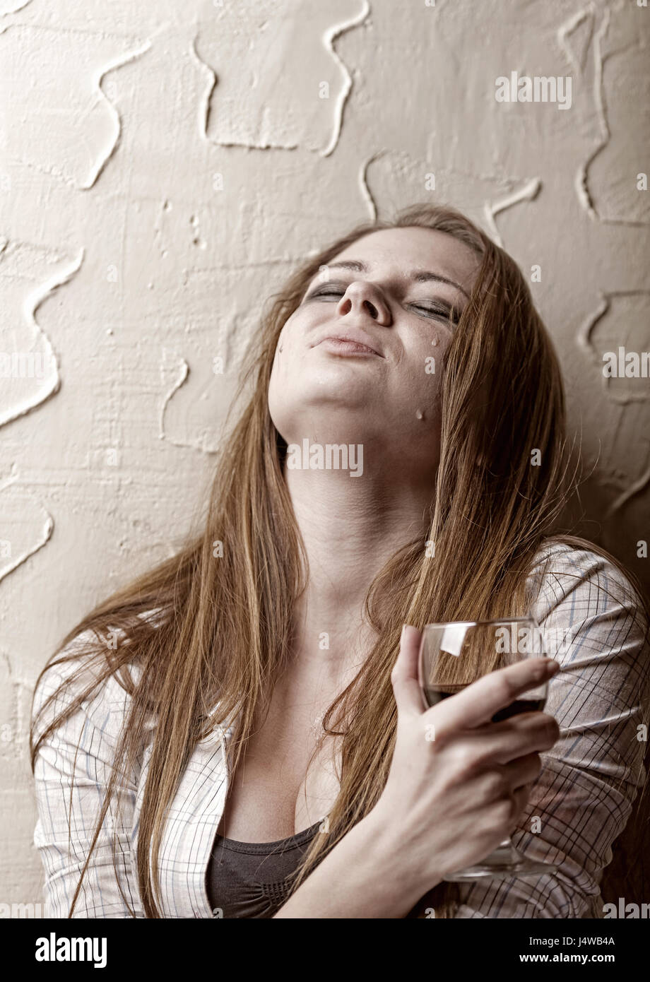 Young crying woman with a glass of wine Stock Photo