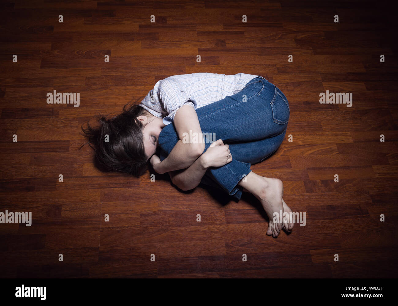 Lying on the floor of a lonely young woman in a empty room Stock Photo