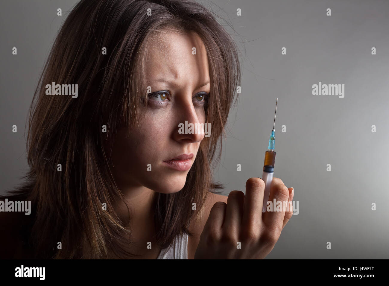 Young woman with drug addiction on dark background Stock Photo