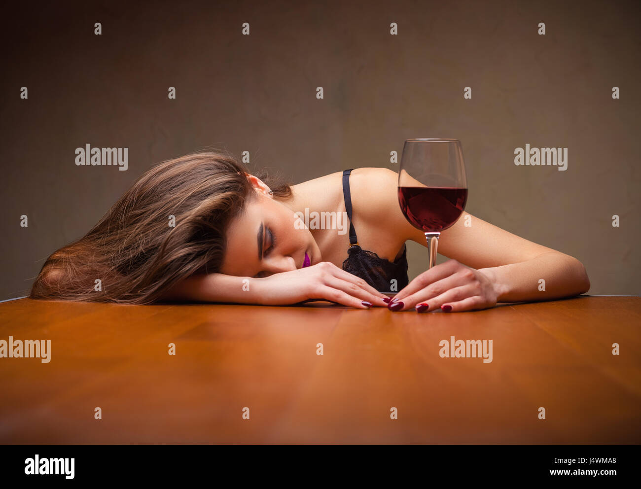 Young beautiful woman in depression, drinking red wine Stock Photo