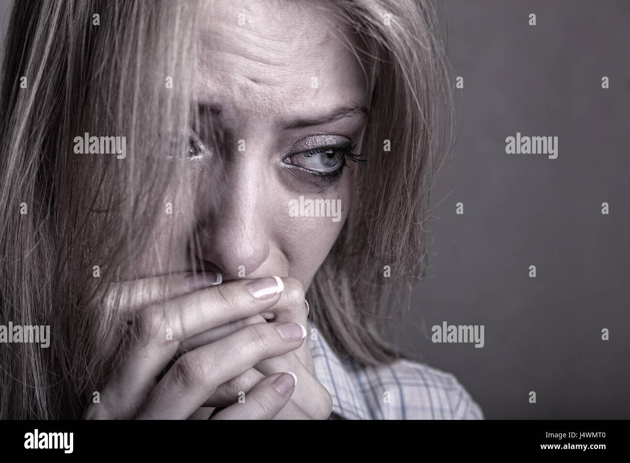Young sad girl crying on a dark background Stock Photo
