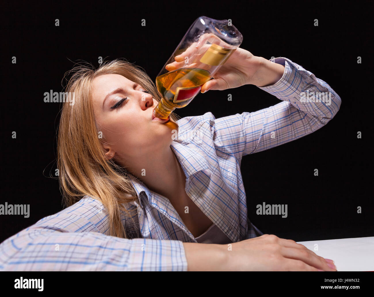 Young beautiful woman in depression, drinking alcohol Stock Photo