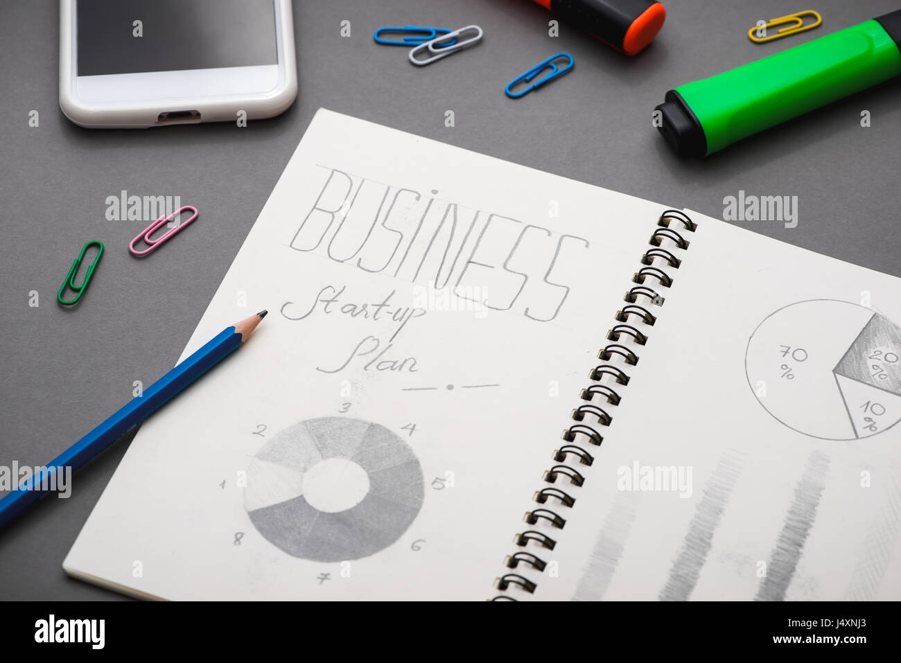 Creative sketch in spiral notepad with laptop on desk. Business starup plan. Stock Photo