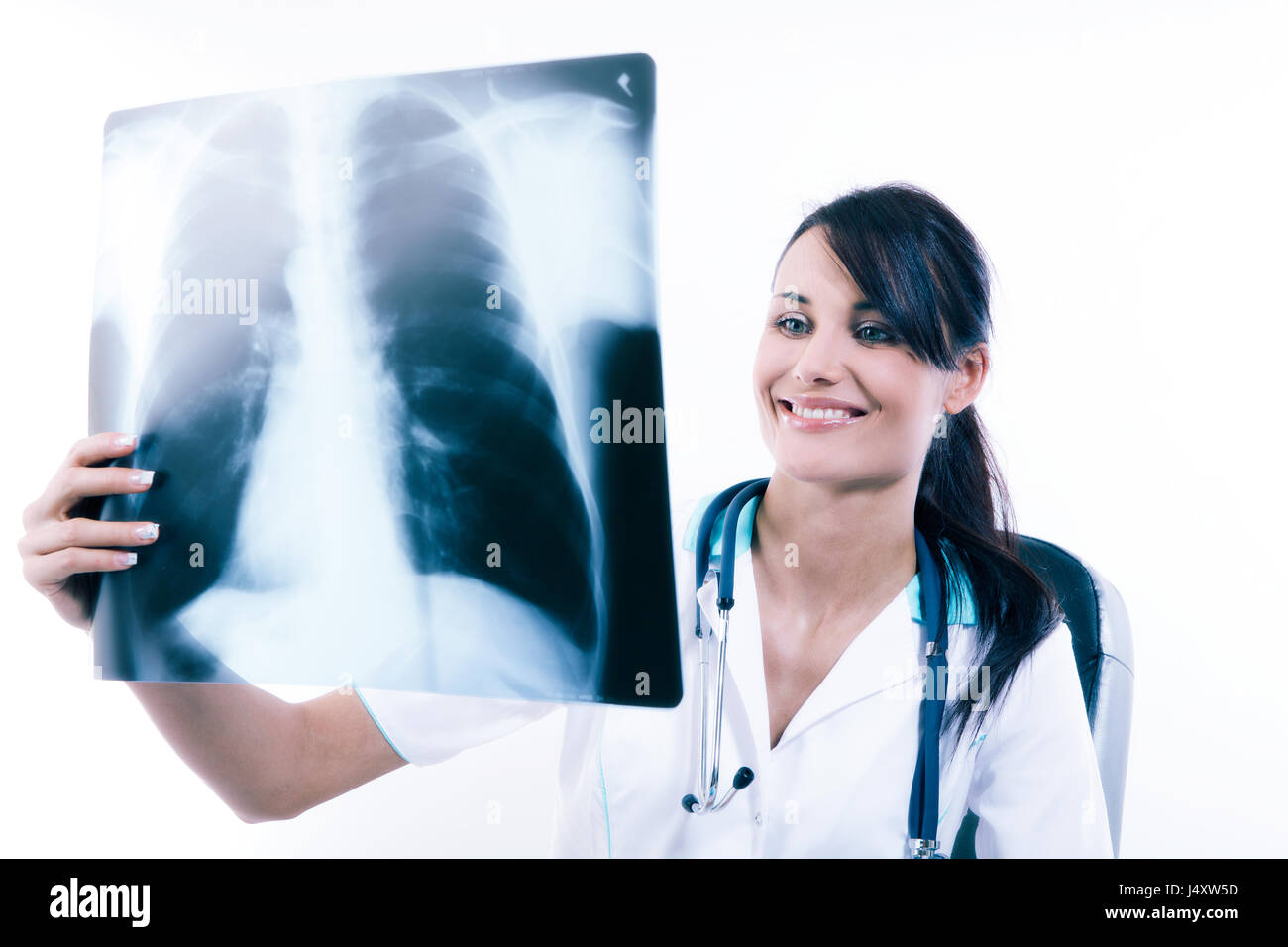 Young female doctor looking at the x-ray picture of lungs in hospital. Health care and prevention concept. Toned image Stock Photo