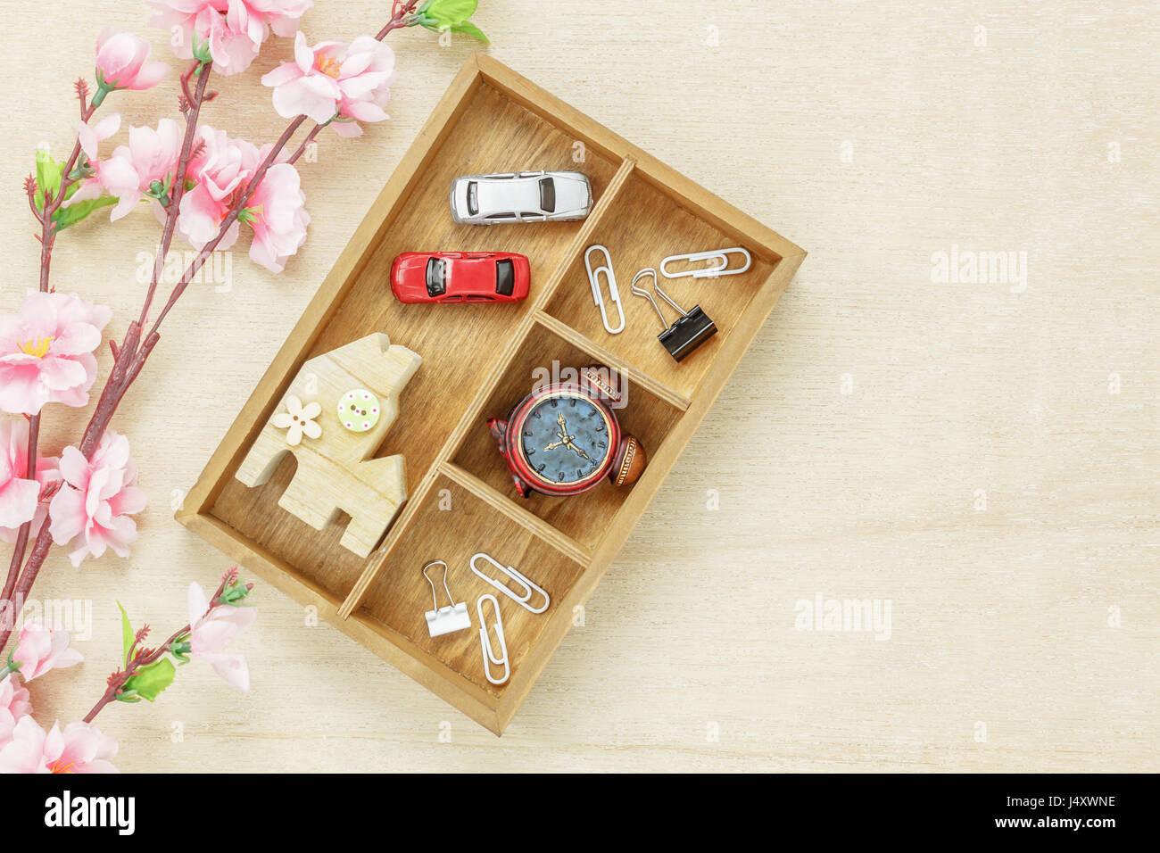Top view business concept. Wood house  also car and clock on wooden shelf.The beautiful pink flower on wood background with copy space. Stock Photo